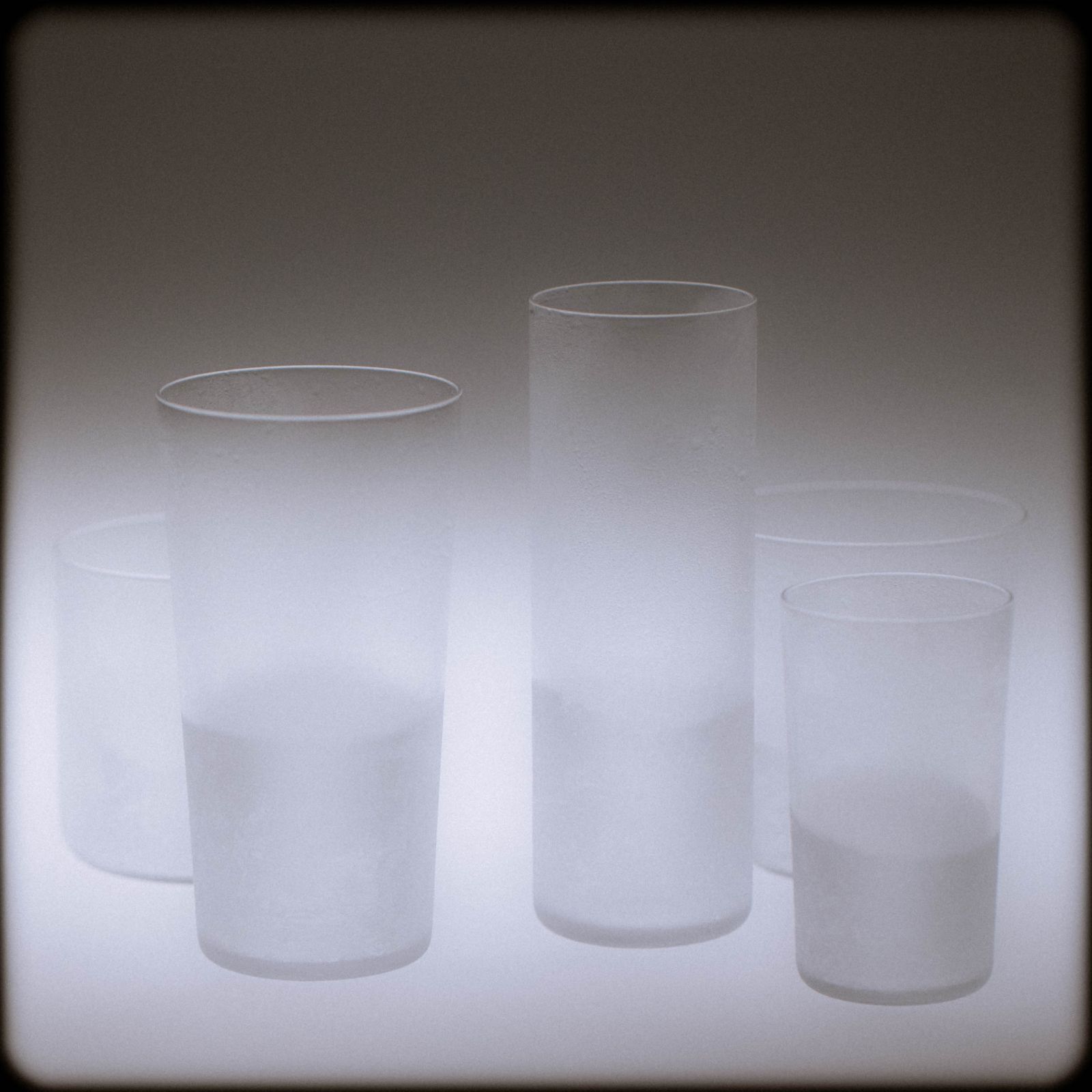 A family of frosted glasses backlit against a soft luminous ground